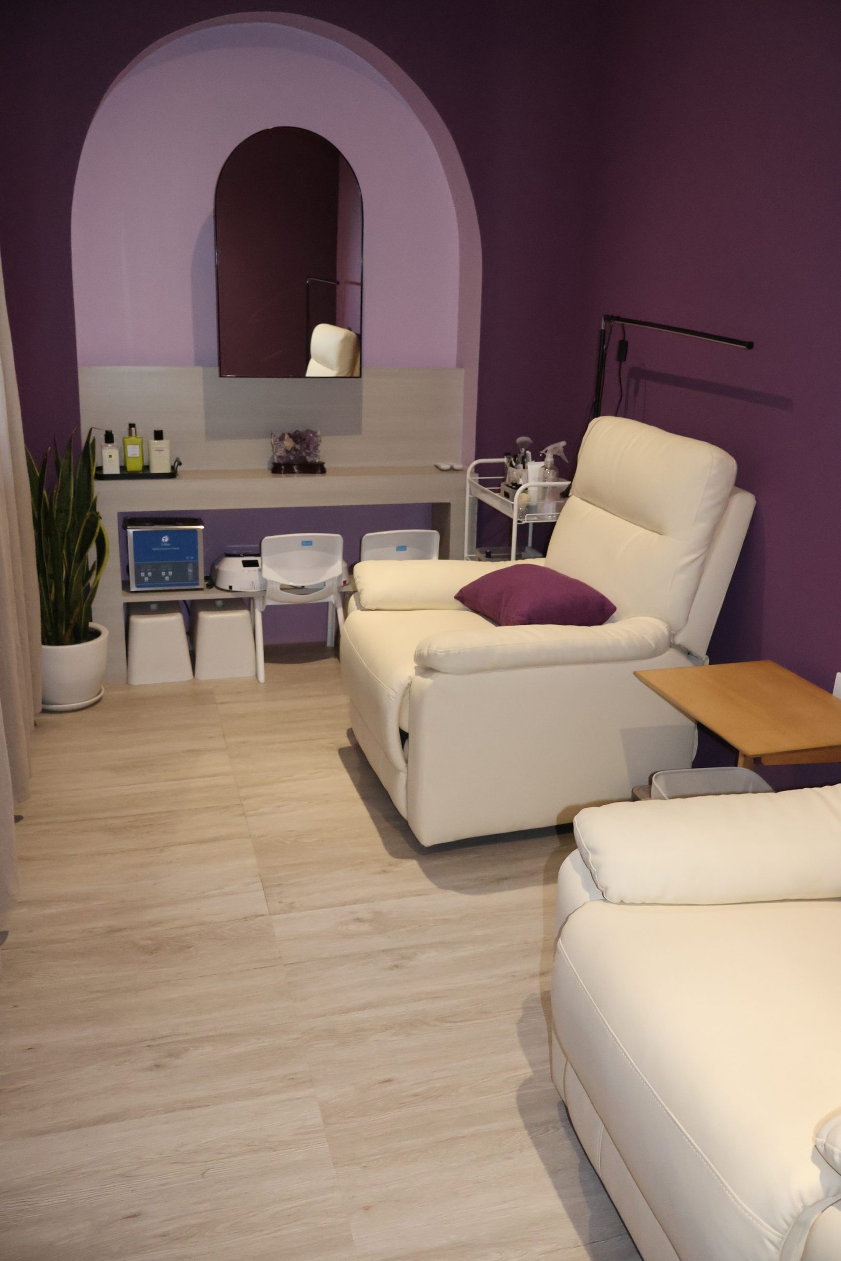 VIP nail room at Lavande, deep aubergine with cream leather recliners.