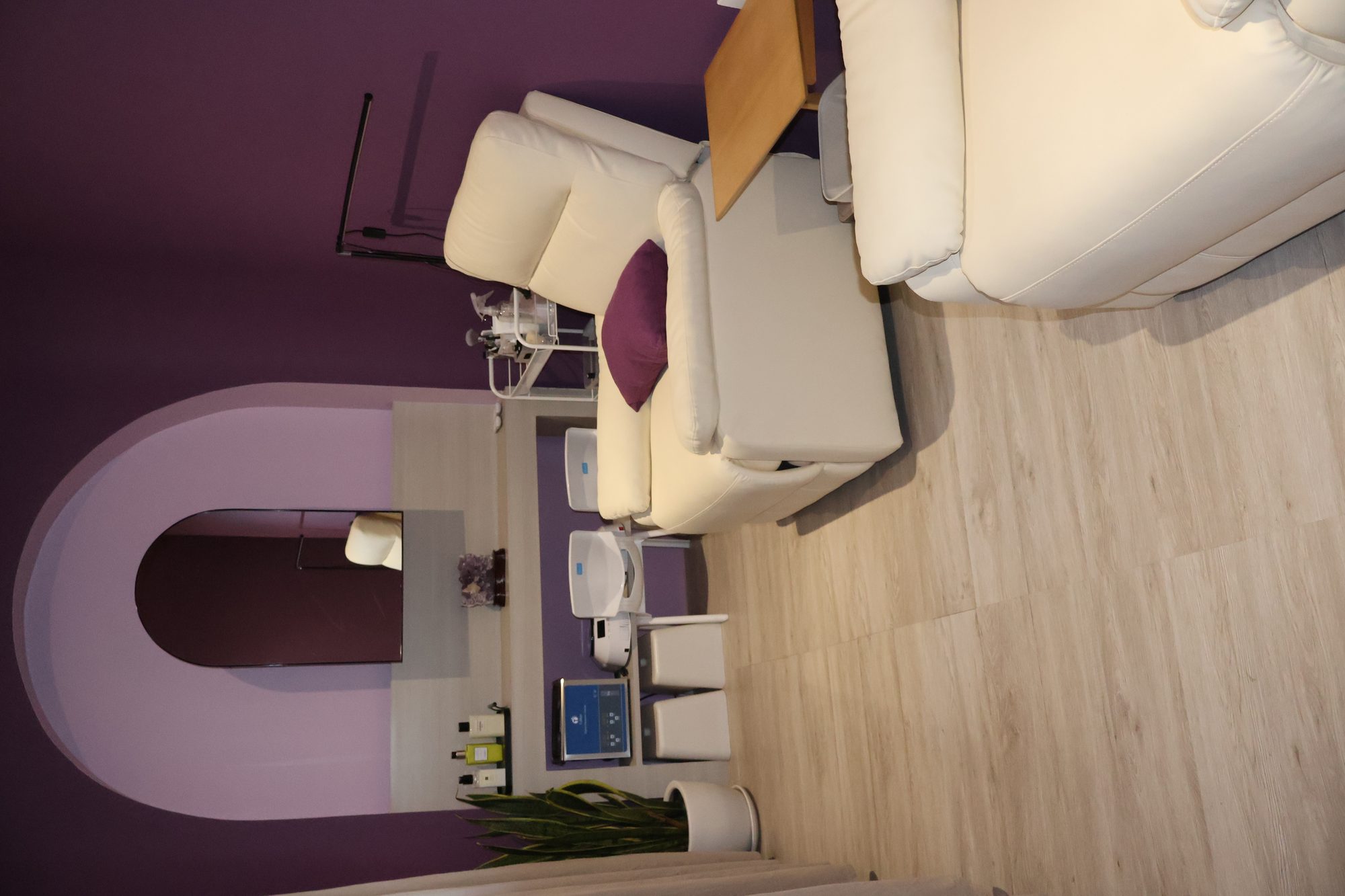 VIP nail room at Lavande, deep aubergine with cream leather recliners.